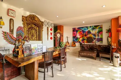 a living room with a wooden table and chairs at Capital O 1666 Grand Pudjawan Hotel Near Kuta Beach in Kuta