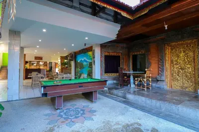 a pool table in the middle of a room at Capital O 1666 Grand Pudjawan Hotel Near Kuta Beach in Kuta
