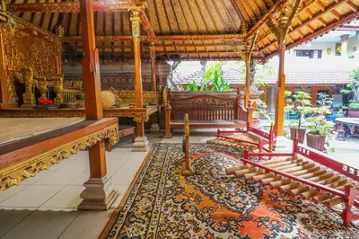 a room with benches and a rug in a building at Capital O 1666 Grand Pudjawan Hotel Near Kuta Beach in Kuta