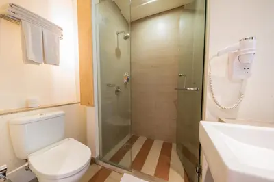 a bathroom with a shower and a toilet and a sink at The ONE Legian in Legian