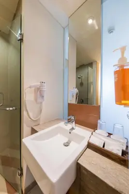 a bathroom with a white sink and a mirror at The ONE Legian in Legian