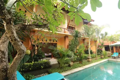a hotel with a swimming pool in front of a building at Mina Pelasa Hotel in Legian