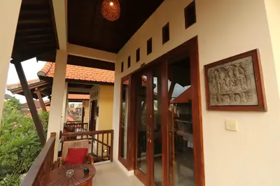 an external view of a house with a balcony at Mina Pelasa Hotel in Legian