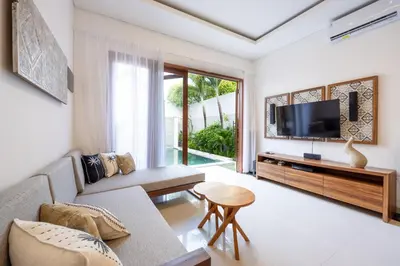a living room with a couch and a tv at Villa Manis La Bora in Seminyak in Seminyak