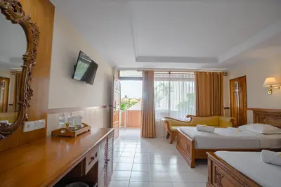 a hotel room with two beds and a balcony at Palm Beach Hotel Bali in Kuta