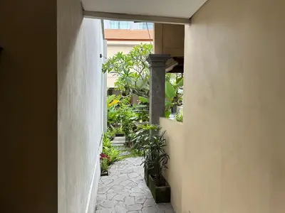 a hallway of a house with plants at Villa Bunga Hotel in Seminyak