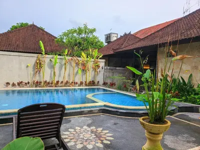 a pool in the backyard of a house at Taman Sari Cottages in Kuta