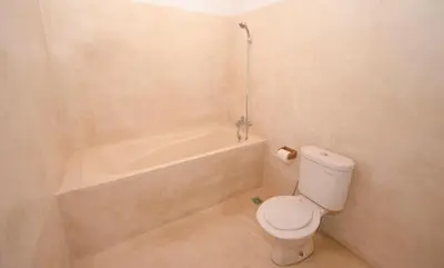 a bathroom with a toilet and a bath tub at Taman Sari Cottages in Kuta