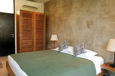 a bedroom with a green bed with two pillows at Wave House Resort Canggu in Canggu