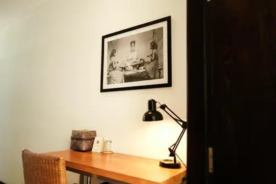 a desk with a lamp and a picture on a wall at Wave House Resort Canggu in Canggu