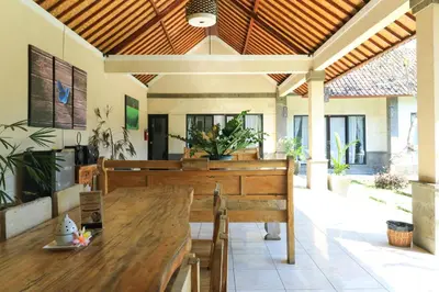 a dining room with a wooden table and a bench at Bali Merita Villa in Canggu
