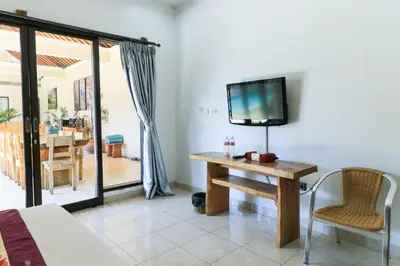 a room with a table and a tv on a wall at Bali Merita Villa in Canggu