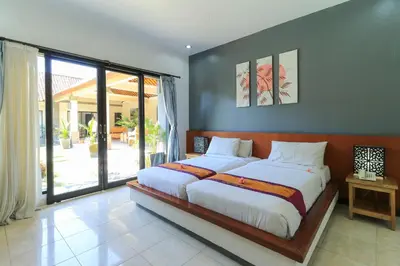 a bedroom with a large bed and a large window at Bali Merita Villa in Canggu