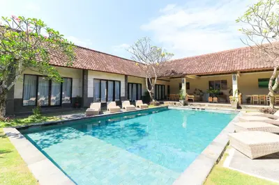 a swimming pool in front of a house at Bali Merita Villa in Canggu