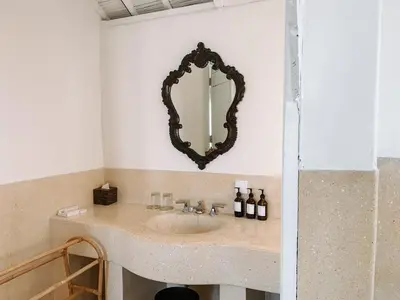 a bathroom with a sink with a mirror on the wall at Kresna By The Sea By Kresna Hospitality in Seminyak