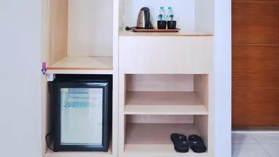 a small room with a small cabinet with a mirror at Conjioo Hotel Kuta Managed By MHM in Legian