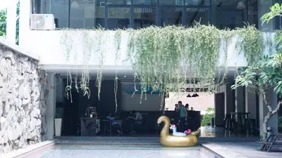 a swan sitting in the courtyard of a building at Conjioo Hotel Kuta Managed By MHM in Legian