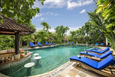 a pool at a resort with blue lounge chairs at Tonys Villas & Resort Seminyak - Bali in Seminyak