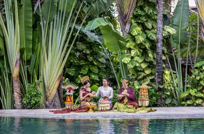 a group of people sitting next to a pool at Tonys Villas & Resort Seminyak - Bali in Seminyak
