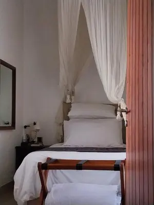 a bedroom with a bed with a canopy at Dim House Jimbaran in Jimbaran