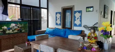 a living room with a table and a fish tank at Turtle Island Homestay in Sanur