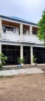 a large building with a balcony on top of it at Turtle Island Homestay in Sanur