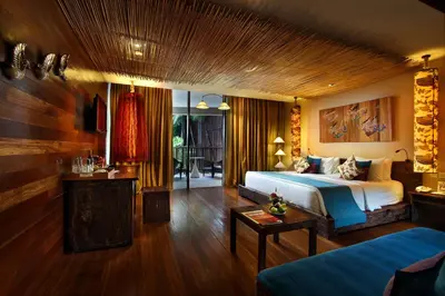 a bedroom with a bed and a living room at Kupu Kupu Jimbaran Beach Hotel & Spa by L’Occitane in Jimbaran