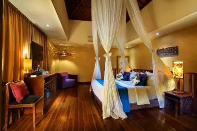 a bedroom with a bed with a mosquito net at Kupu Kupu Jimbaran Beach Hotel & Spa by L’Occitane in Jimbaran