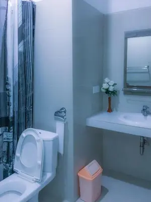 a white bathroom with a toilet and a sink at Degung de brata Family villas in Legian