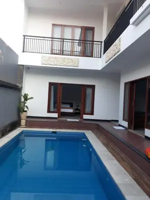 a swimming pool in the middle of a house at Degung de brata Family villas in Legian