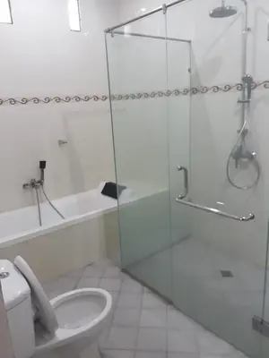 a bathroom with a glass shower and a toilet at Degung de brata Family villas in Legian