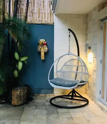 a swinging chair in a room with a blue wall at Villa Bebek in Seminyak