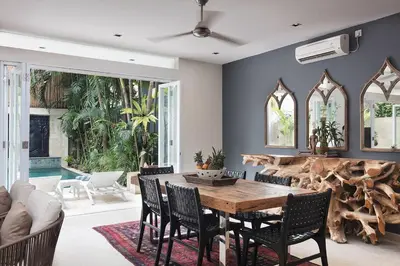 a dining room with a wooden table and chairs at Villa Bebek in Seminyak