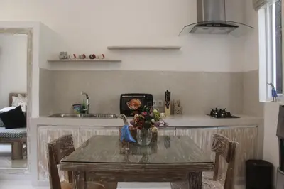 a table with a vase of flowers on it in a kitchen at Green Studio Apartment Seminyak in Seminyak
