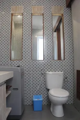 a bathroom with a toilet and three mirrors at Green Studio Apartment Seminyak in Seminyak