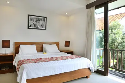 a bedroom with a bed and a large window at Seminyak TownHouse in Legian