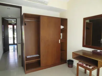 a room with a wooden closet and a tv at Seminyak TownHouse in Legian