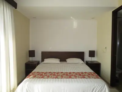 a bedroom with a large bed with two night stands at Seminyak TownHouse in Legian
