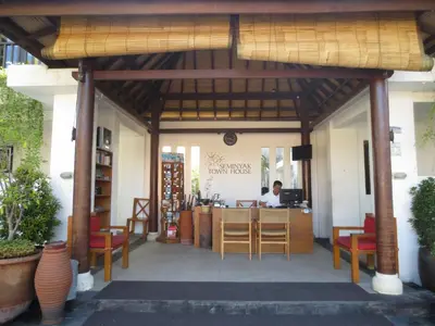 a restaurant with a man sitting at a counter at Seminyak TownHouse in Legian