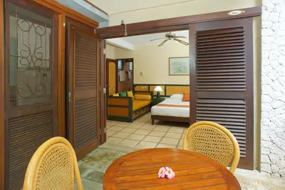 a room with a table and chairs and a bedroom at Pondok Agung Bed & Breakfast in Nusa Dua
