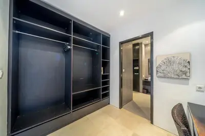 a walk in closet with black sliding doors at The Town House in Seminyak