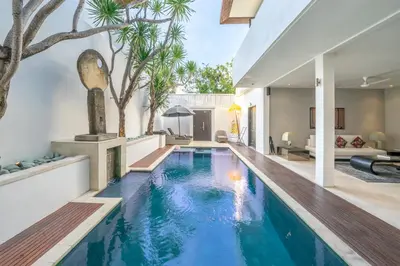 an infinity pool in a house with a living room at The Town House in Seminyak