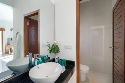 a bathroom with a sink and a toilet and a mirror at Super Value 3 Bed, Central Seminyak, Walk to Beach in Seminyak