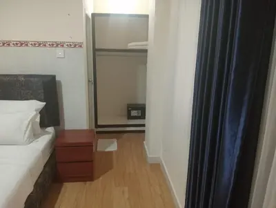 a small bedroom with a bed and a mirror at City Garden Bali Dwipa Hotel, Kuta in Kuta