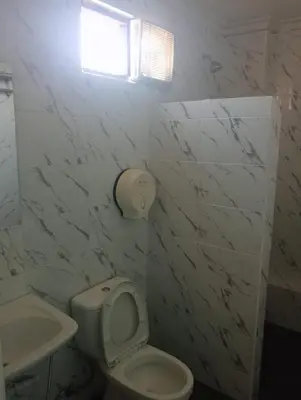 a bathroom with a toilet and a sink and a window at City Garden Bali Dwipa Hotel, Kuta in Kuta
