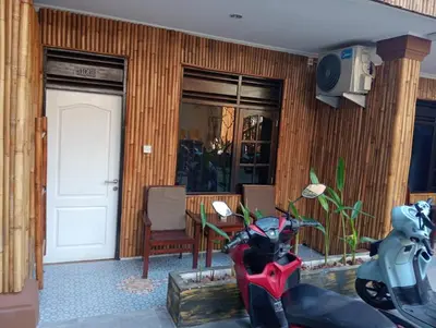 a red motorcycle parked in a room with a door at City Garden Bali Dwipa Hotel, Kuta in Kuta