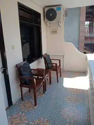 a room with two chairs and a table and a window at City Garden Bali Dwipa Hotel, Kuta in Kuta