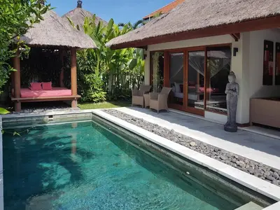 a swimming pool in front of a villa at Villa Kakariki in Kerobokan