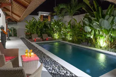 a swimming pool in the middle of a resort at Villa Kakariki in Kerobokan