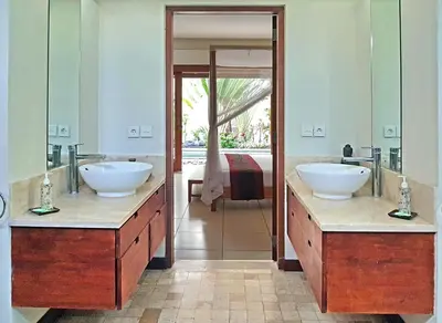 a bathroom with two sinks and a large mirror at Villa Kakariki in Kerobokan